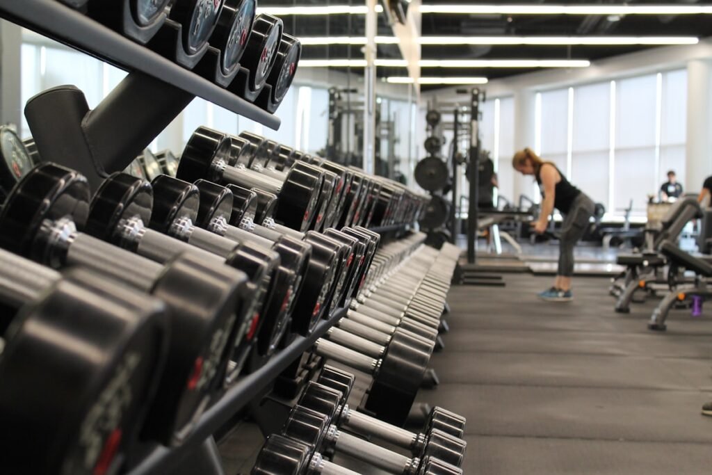 Person doing home workout with resistance bands and dumbbells in Canada